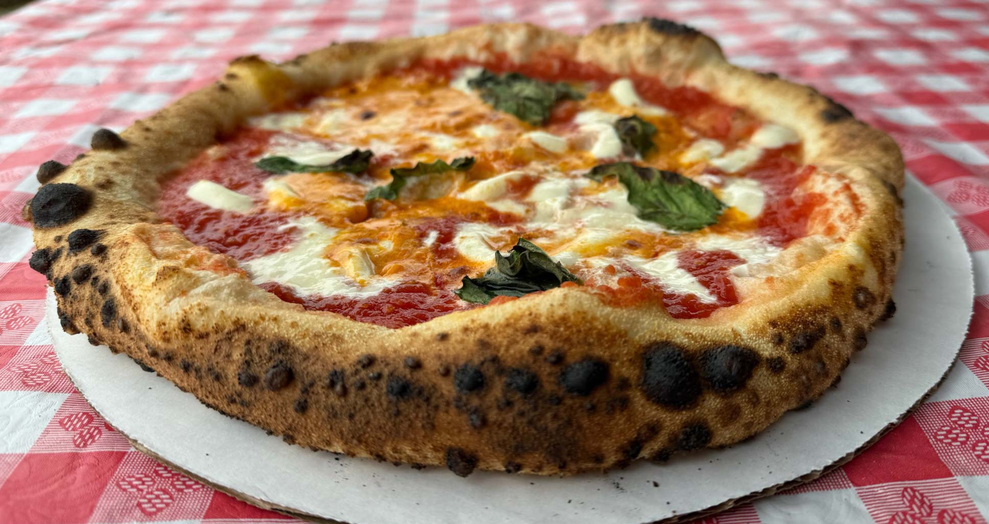 Pizzeria Loco's iconic cannoto-style cornicione on a mouthwatering Margherita topped with fresh basil and Loco Sauce